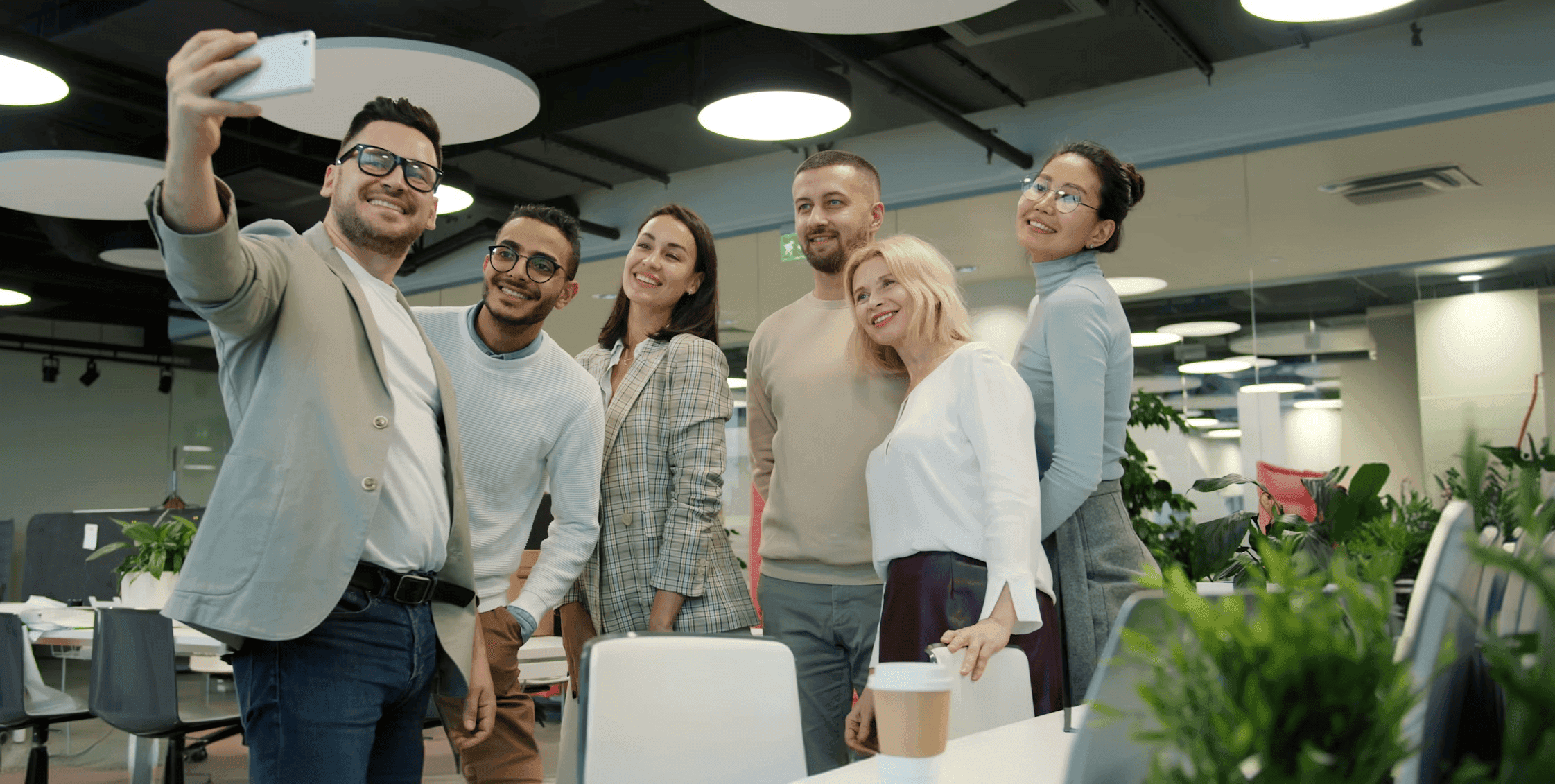 Six Pay2Easy team members smiling and taking a group selfie in the office